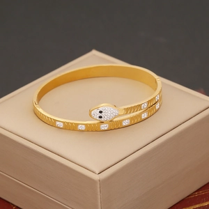 Detailed macro view of gold-plated snake bracelet with crystal inlay on jewelry box
