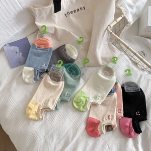 Colorful low cut cotton socks for women with minimalist smiley face embroidery on fabric