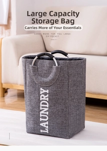 Close-up of grey fabric laundry basket with round metal handles in a modern living room