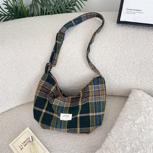 Detail of colorful plaid tweed crossbody hobo bag on a cozy minimalist background