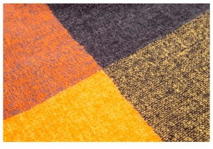 Close-up of thick knitted fabric with orange, yellow, and grey oversized plaid pattern