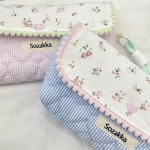Detail of floral quilted pencil cases with heart buttons and soft texture close-up