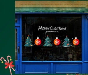 Nahaufnahme der roten und grünen Weihnachtsfensteraufkleber mit Text auf Glasoberfläche