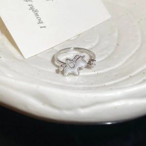 Macro shot of silver unicorn ring with white enamel and sparkling zircon details