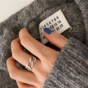 Detail shot of a silver S925 sterling silver chunky Cuban chain ring worn on finger