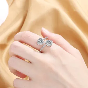Close-up of sparkling heart-shaped zircon rings on elegant champagne satin fabric