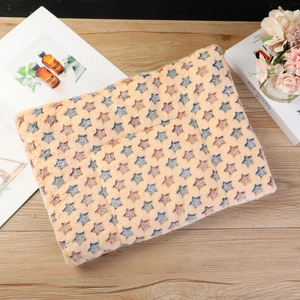 Detailed plush pet blanket with yellow and orange stars on a warm wooden background