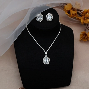 Macro view of crystal teardrop necklace and earring set on a black bust display