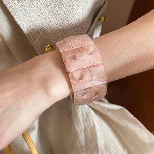 Close-up of pink marble texture resin acrylic stretch bracelet worn on wrist