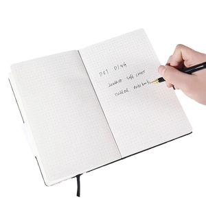 Flat lay of soft cover dotted journal notebook with premium pen for writing