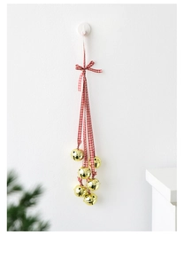Detail of golden metal bells with a red and white checkered ribbon bow for Christmas decor
