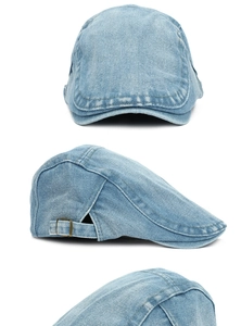 Macro shot of light blue denim ivy cap showing metal buckle and washed fabric texture