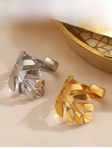Detailansicht der verstellbaren Monstera-Blattringe in Gold und Silber auf Stoff