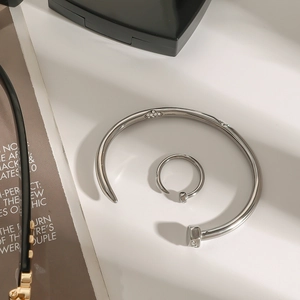 Silver nail-shaped bangle and ring set with sparkling zircon pavé in industrial style