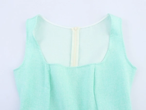 Detail of mint green sleeveless dress showing textured tweed fabric and invisible zipper