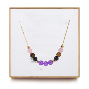 Detail of beaded gemstone necklace with quartz and amethyst in a kraft gift box