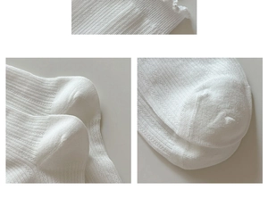 Close-up of white ribbed knit cotton socks showing detailed texture and seamless heel stitching