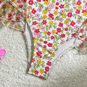 Détail d'un maillot de bain à fleurs avec volants en maille et texture de tissu doux