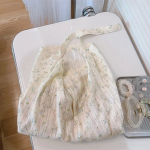 Detail of floral lace cotton tote bag showing light blue flower patterns and soft texture