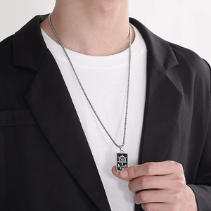 Détail du collier pendentif carré gouvernail et ancre porté avec un blazer chic