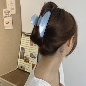 Detail of light blue butterfly hair claw clip on model in a soft French aesthetic style
