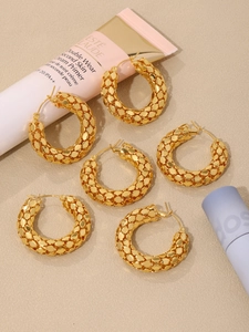 Macro detail of 18k gold plated U-shaped hoop earrings with woven honeycomb texture