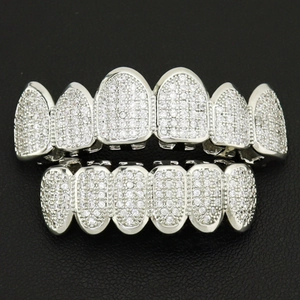 Macro shot of silver hip hop grillz set with sparkling pavé zircons on black background