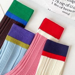 Detail of colorful ribbed knit crew socks with vibrant color-block patterns in cotton blend