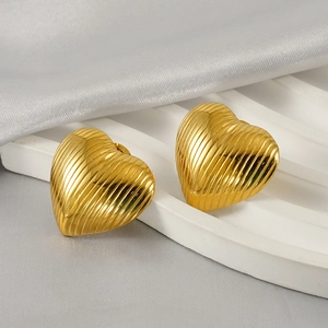 Detailed close-up of gold heart stud earrings with elegant vertical stripe texture