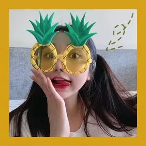 Funny yellow pineapple party glasses with green leaves for creative photo shoots