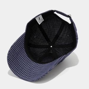 Detail view of cotton baseball cap interior showing plaid pattern and fabric care label