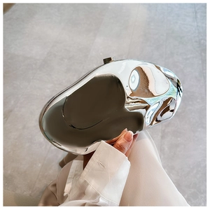 Close-up of silver irregular liquid metal clutch bag with mirrored finish and snap closure