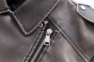 Macro du col à revers, du zip métallique et du cuir vintage de la veste de motard