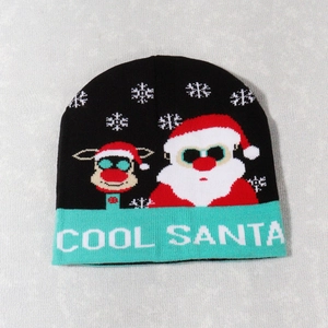Detail of black Christmas knit hat with cyan brim showing cool Santa and reindeer patterns