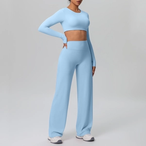 Detailed close-up of light blue high-waist wide-leg pants and cropped long-sleeve yoga top