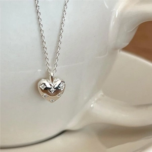925 silver heart necklace with zircon inlay and floral pattern on a ceramic cup edge