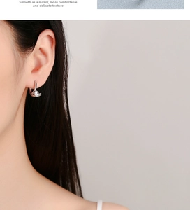 Close-up of 925 sterling silver hoop earring with round zircon on female model ear