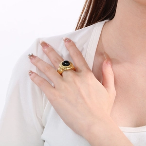 Detailed view of fashion chunky lava texture gold ring with black enamel on a model hand