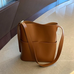 Detailansicht einer braunen Kunstleder-Beuteltasche mit breitem Gurt und Fronttaschen