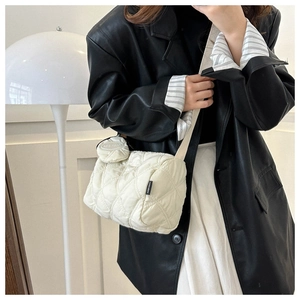 Détail du sac bandoulière matelassé crème en nylon avec petite pochette et étiquette