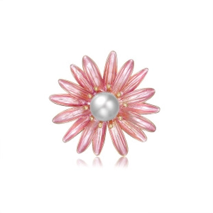 Close-up of elegant pink enamel daisy brooch with a central pearl and gold metal trim