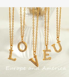 Detailed view of five gold necklaces featuring rhinestone-encrusted LOVE U letter pendants
