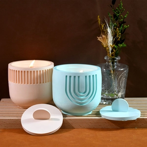 Detailed view of striped and geometric textured candle jars with matching lids on wood