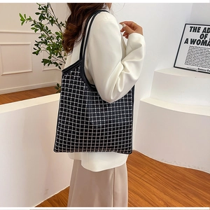 Detailansicht der großen schwarzen Strass-Gitter-Tasche kombiniert mit weißem Blazer