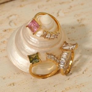 Adjustable 18K gold stainless steel rings with pink and green stones on a white seashell