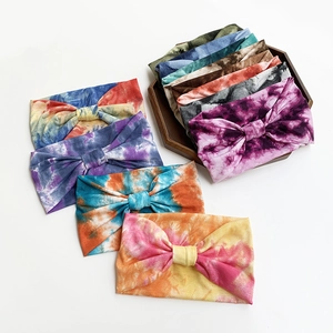 Wide tie-dye yoga headbands made of elastic cotton, displayed in various colors on a tray