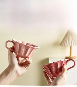 Detail of pink scalloped ceramic cup and saucer set with a smooth glaze finish