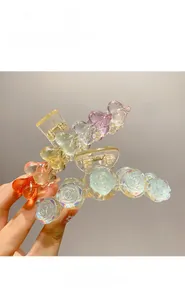 Close-up of iridescent acrylic shark hair clips with rose and heart bubble designs
