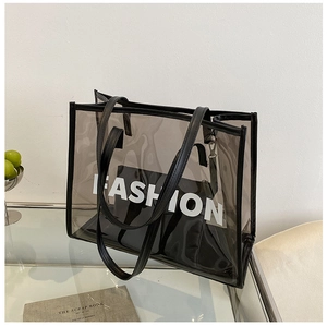 Detail view of transparent black PVC tote bag with leather strap and fashion print