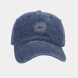 Gros plan de la casquette en coton lavé marine avec broderie détaillée de tournesol blanc